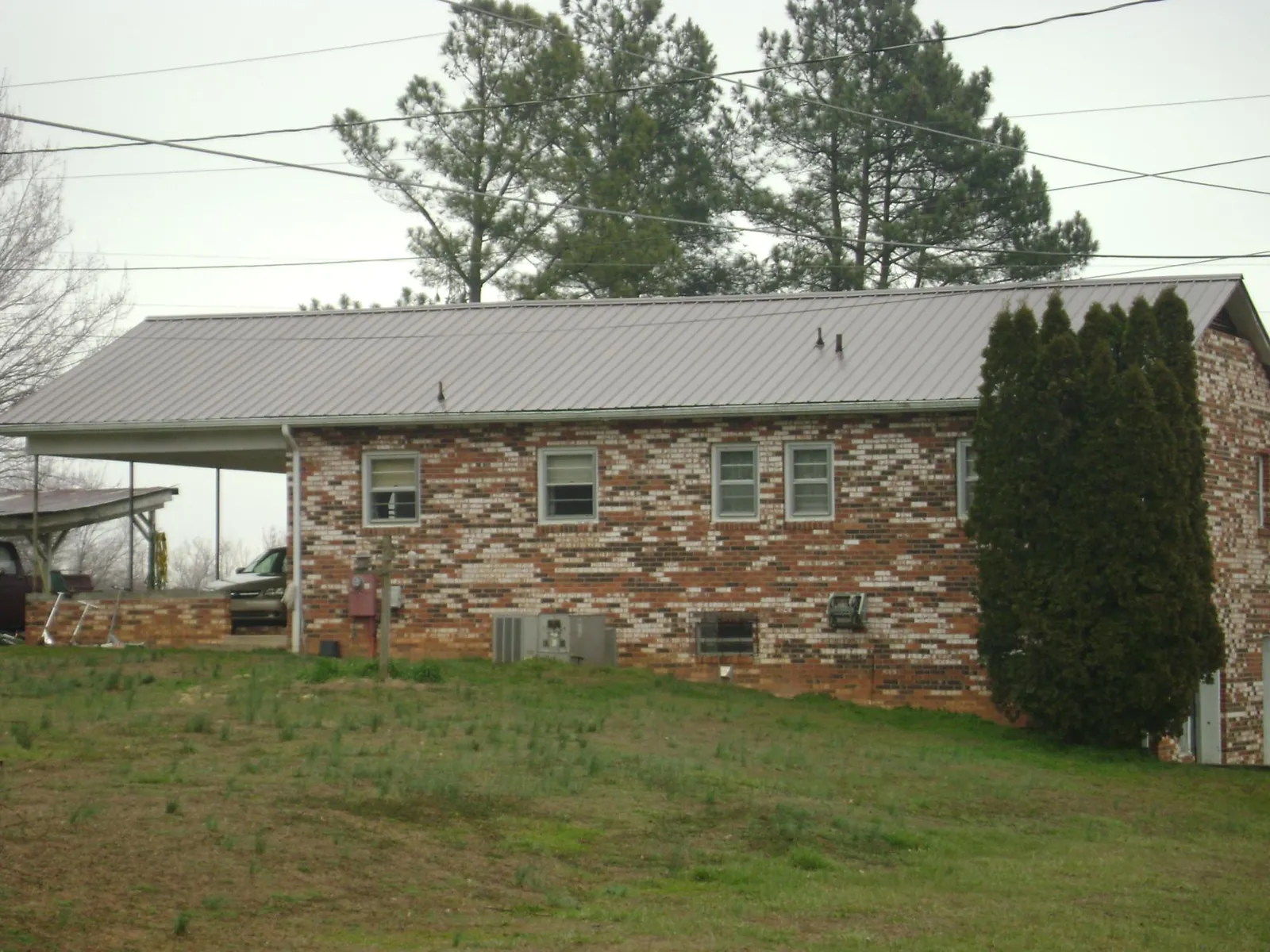 Gray metal roof on a brick split level home with a carport in Cape May Point